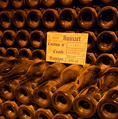 Opgestapelde Champagne flessen in de kelders van Champagne huis Ruinart in Reims